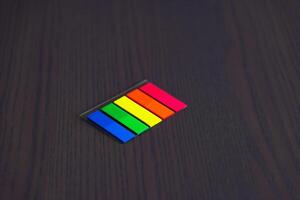 Stationery on the desk in the office. Multicolored bookmarks. Copy space. photo