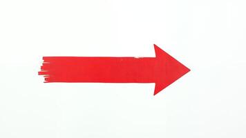 Bold red arrow painted on a white background guiding the viewer direction photo