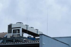 Rooftop cooling system and antennas overlooking a cloudy sky photo