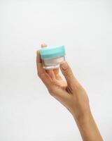 female hands hold a jar of cream on a white background photo