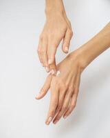 female hands apply cream one on top of the other on a white background photo