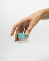 female hands hold a jar of cream on a white background photo