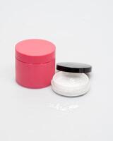red jar with powder and white jar with cream on a white background photo