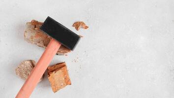 Sledgehammer construction tool on red bricks on concrete background, floor. Flat lay with copy space photo