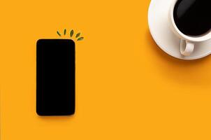 Cup of coffee and smartphone, phone on a yellow background with copy space. Blogger photo