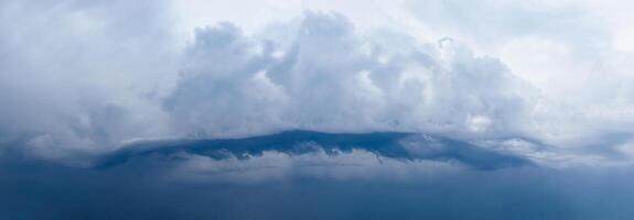 Cyclone thundercloud panorama of interesting shape. The sky before the rain. Dark Clouds photo