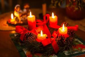 Advent wreath made of pine branches with four burning candles photo