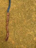 blue cable with stripped copper core on yellow floor photo