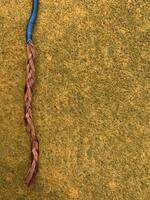 blue cable with stripped copper core on yellow floor photo