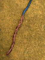 blue cable with stripped copper core on yellow floor photo