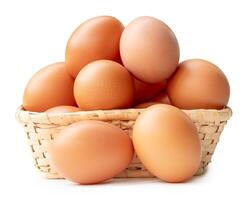 Group of fresh brown chicken eggs in stack in wicker basket isolated on white background with clipping path photo