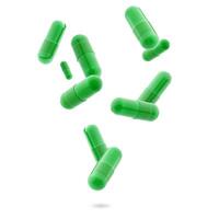 green medical gel capsules falling down on white background. food supplement, pharmacy concept. plastick capsules pills photo