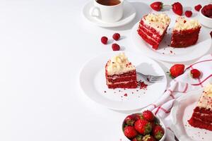 Pieces of red velvet cake on plates, berries and towel on white background, space for text photo