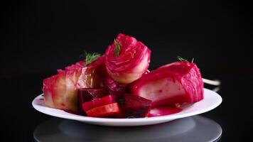 pickled cabbage with beets and carrots, in a plate, isolated on black background video
