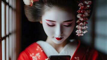 Portrait of a young Japanese geisha using a mobile phone. Representation of the adaptation of technology to the most traditional in Japan. photo