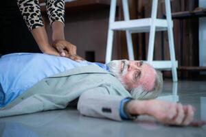 An elderly businessman suffered a sudden heart failure at work, A coworker was administering CPR to offer basic life support. photo