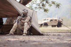 Portrait of soldiers in camouflage uniforms hold weapons in front of a field tent, Prepare for combat training photo