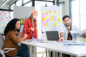Multiethnic young business people working together in modern office, Collaborate to designing an application for use on the internet network. photo