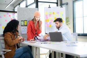 Multiethnic young business people working together in modern office, Collaborate to designing an application for use on the internet network. photo
