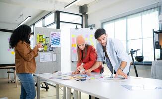 Multiethnic young business people working together in modern office, Collaborate to designing an application for use on the internet network. photo
