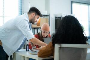 Multiethnic young business people working together in modern office, Collaborate to designing an application for use on the internet network. photo