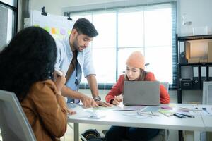 Multiethnic young business people working together in modern office, Collaborate to designing an application for use on the internet network. photo