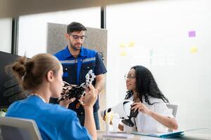 Engineers, doctors and physical therapists brainstorm ideas to design a robot with arm and hand organs, To be utilized for additional testing on patients. photo