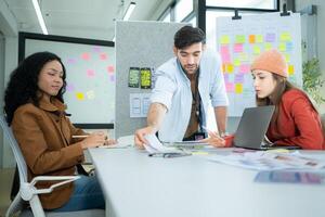 Multiethnic young business people working together in modern office, Collaborate to designing an application for use on the internet network. photo