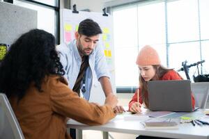 Multiethnic young business people working together in modern office, Collaborate to designing an application for use on the internet network. photo