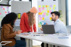 Multiethnic young business people working together in modern office, Collaborate to designing an application for use on the internet network. photo