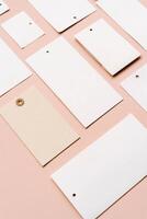 White price labels, blank tags with different shapes and sizes on a beige background. photo