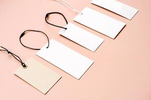 White price labels, blank tags with different shapes and sizes on a beige background. photo