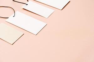 White price labels, blank tags with different shapes and sizes on a beige background. photo