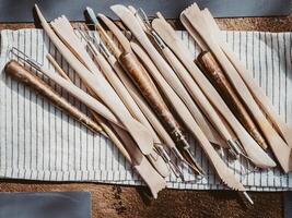 Set of clay modeling tools on white napkin background on wood table photo