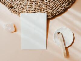 White blank card for text mockup, pink crystal and palo santo on beige background. photo
