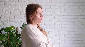 upset millennial woman standing indoors at home looking, facial expression worry about trouble or problem, looking at the window video