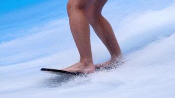 Close-up legs surfer balancing on surfboard. Water sports activity. Instructor demonstrating how to stand up on surfboard. The concept of practice and perseverance before it succeeds. Free copy space video