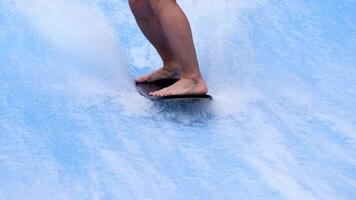 fechar-se pernas surfista balanceamento em prancha de surfe. água Esportes atividade. instrutor demonstrando quão para ficar de pé acima em prancha de surfe. a conceito do prática e perseverança antes isto sucesso. livre cópia de espaço video