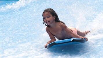 pequeno menina surfista balanceamento em uma prancha de surfe. água Esportes atividade. criança Aprendendo quão para ficar de pé acima em prancha de surfe. a conceito do prática e perseverança antes isto sucesso. livre cópia de espaço video