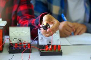 Students experiment with simple electronic circuits. Principles of traffic light circuits. Soft and selective focus. photo