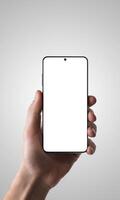 Hand holding a smartphone with an isolated screen against a gray background, perfect for promoting apps, showcasing mobile technology, or mockup designs photo