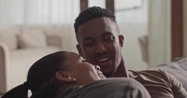 Diverse couple cuddling on sofa video