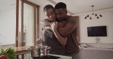 Couple hugging and talking during lunch preparation video