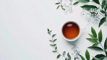 Isolated Cup of Tea Surrounded by Greenery on White Background photo