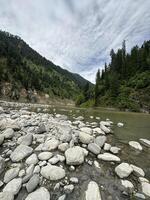 A river with rocks and trees in the foreground photo