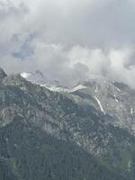 A plane flying over a mountain range with snow capped peaks photo