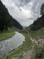 A river runs through a valley surrounded by mountains photo