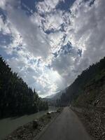 A road with a river and mountains in the background photo