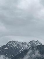 A plane flying over a mountain range with clouds photo