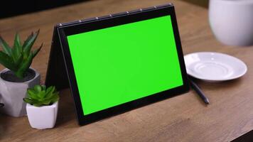 A tablet with a green screen placed on a table, ideal for showcasing app demos, product displays, or digital content creation in a clean and minimal setting. video